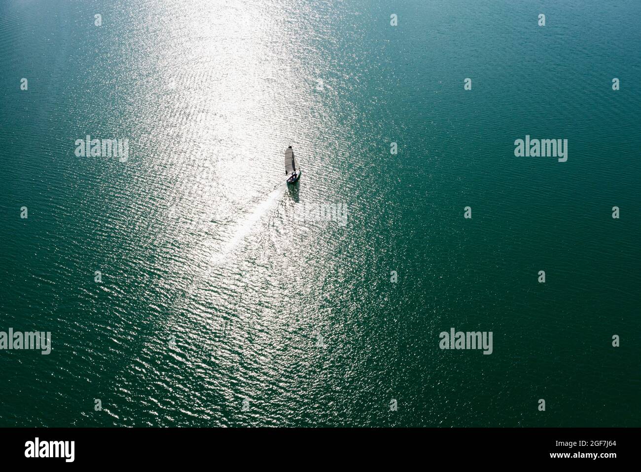 Drone shot, sailboat from above at the lake in backlight with water reflection, Mondsee, Salzkammergut, Upper Austria, Austria Stock Photo