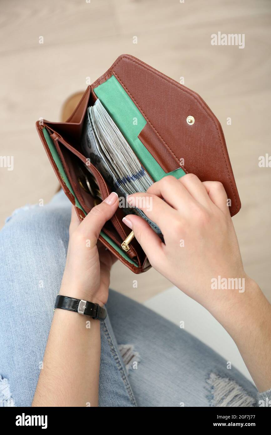 Girl with brown wallet full of money Stock Photo - Alamy