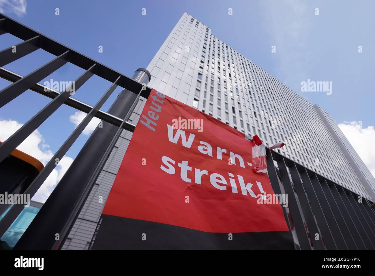 Berlin, Germany. 24th Aug, 2021. A banner with the inscription 'warning strike' is seen in front of the Charité hospital tower. At the state-owned hospitals Vivantes and Charité in Berlin, the three-day strike of nursing staff and other employees has been going on since the day before. The employees of Charité, Vivantes and the Vivantes subsidiaries are demanding better working conditions. Credit: Jörg Carstensen/dpa/Alamy Live News Stock Photo