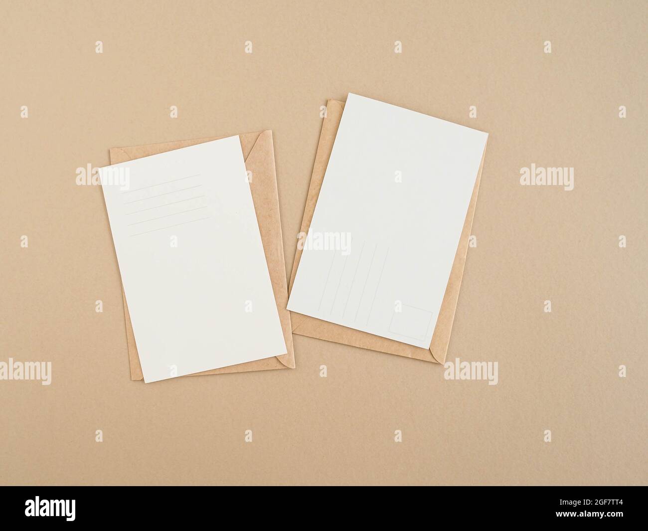 Two blank postcards and envelopes on beige background. Top view Stock