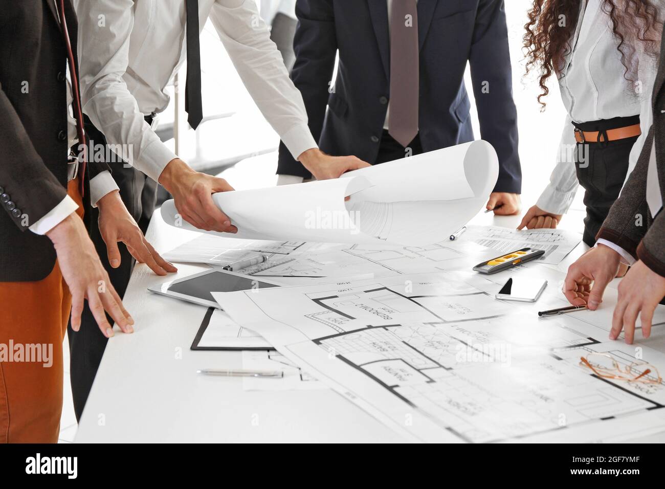 Team of professional engineers working with blueprints Stock Photo - Alamy