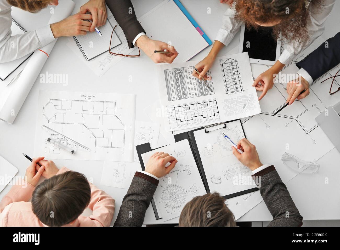 Team of professional engineers working with blueprints Stock Photo - Alamy