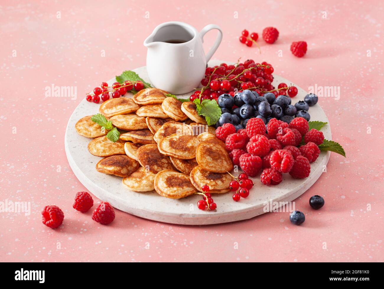 american mini pancake board with berries and maple syrup Stock Photo