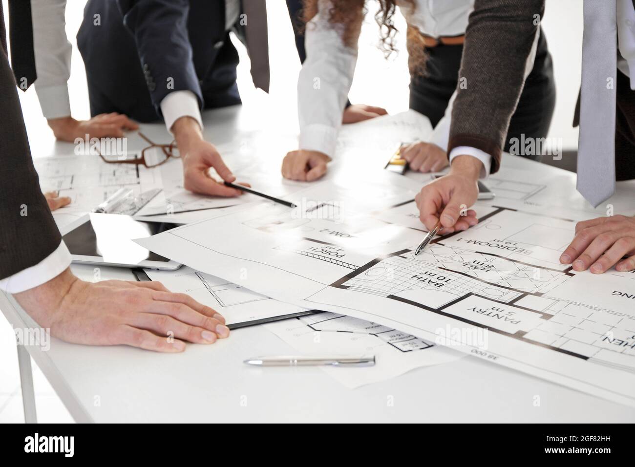 Team of professional engineers working with blueprints Stock Photo - Alamy