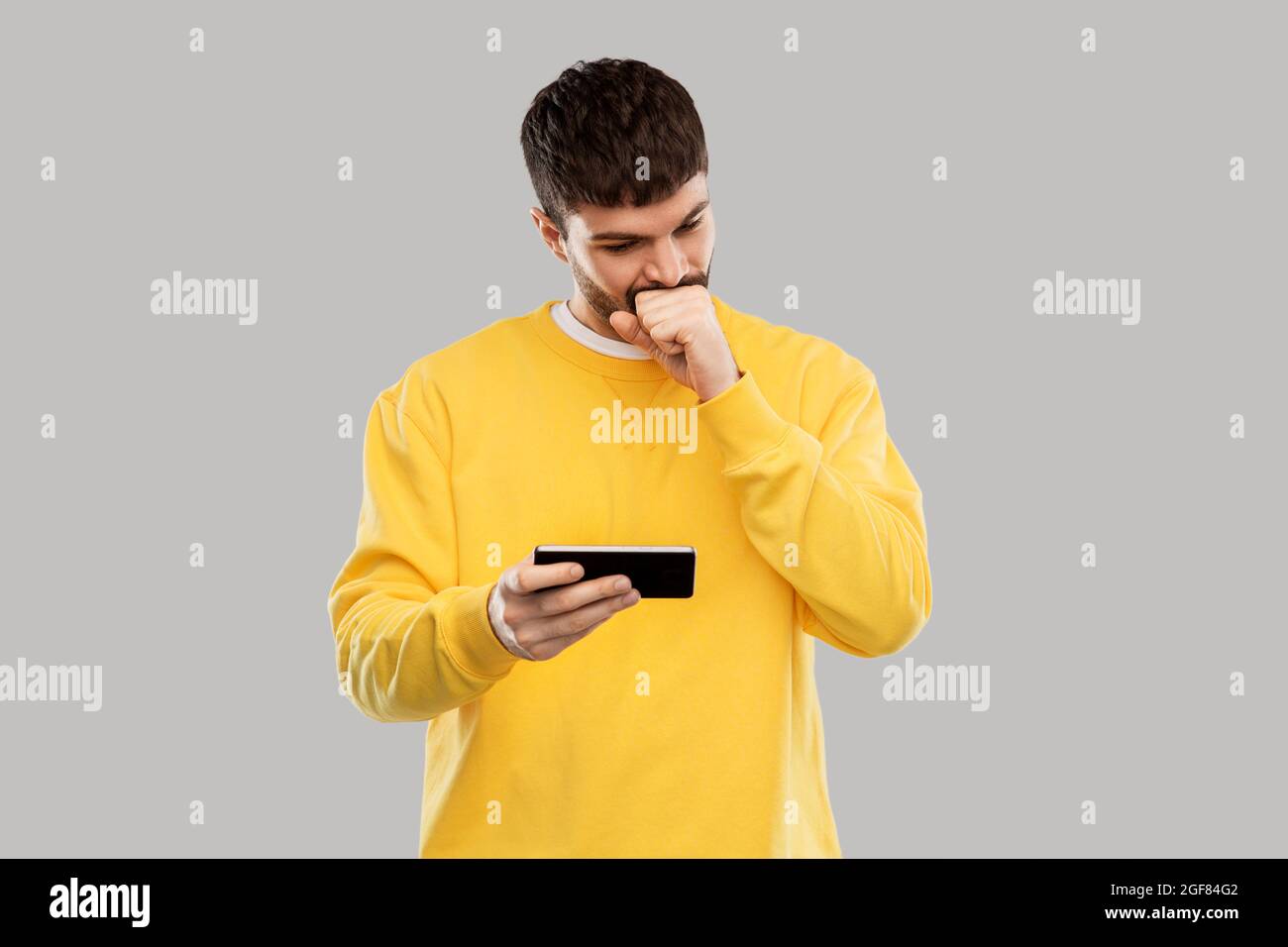 puzzled young man with smartphone Stock Photo