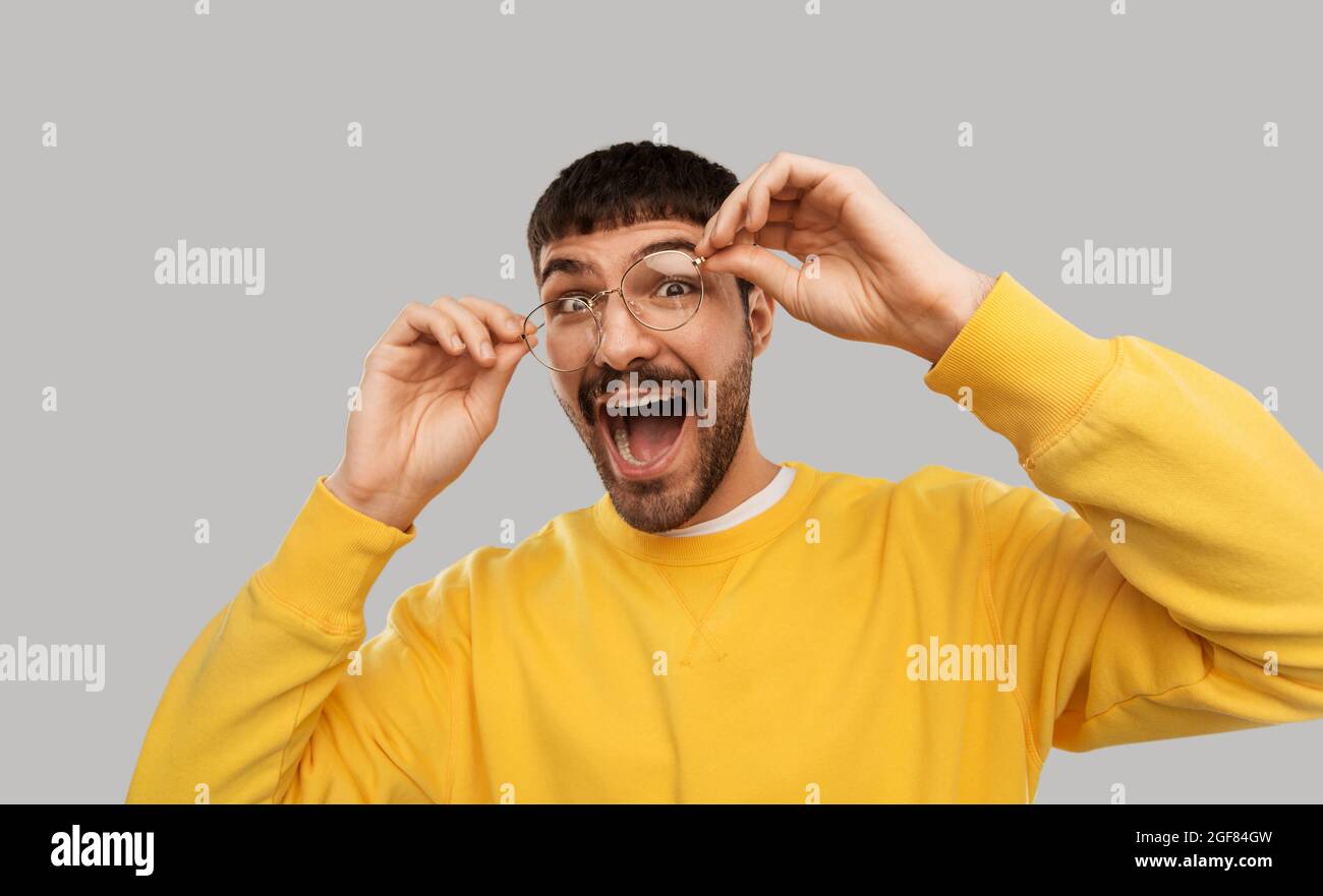 goofy young man in glasses and yellow sweatshirt Stock Photo
