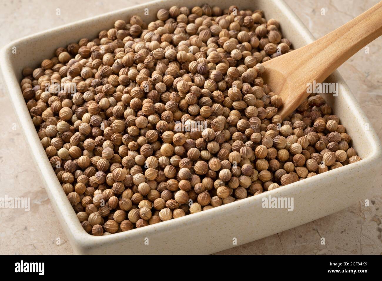Bowl with dried organic coriander seeds close up Stock Photo