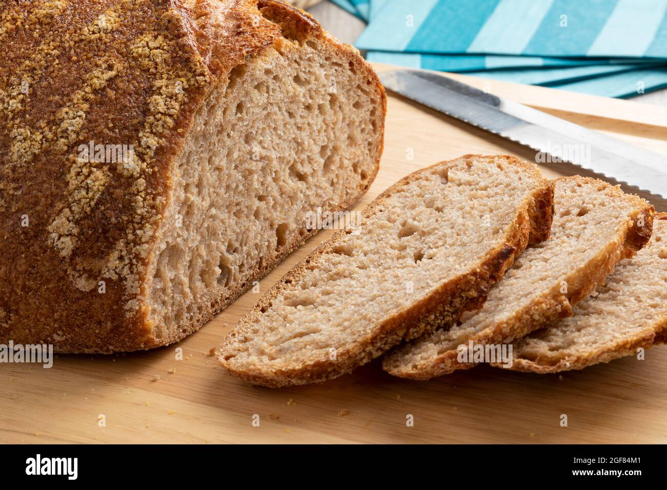 Sliced whole fresh baked German dinkel wheat bread on a cutting board close up Stock Photo