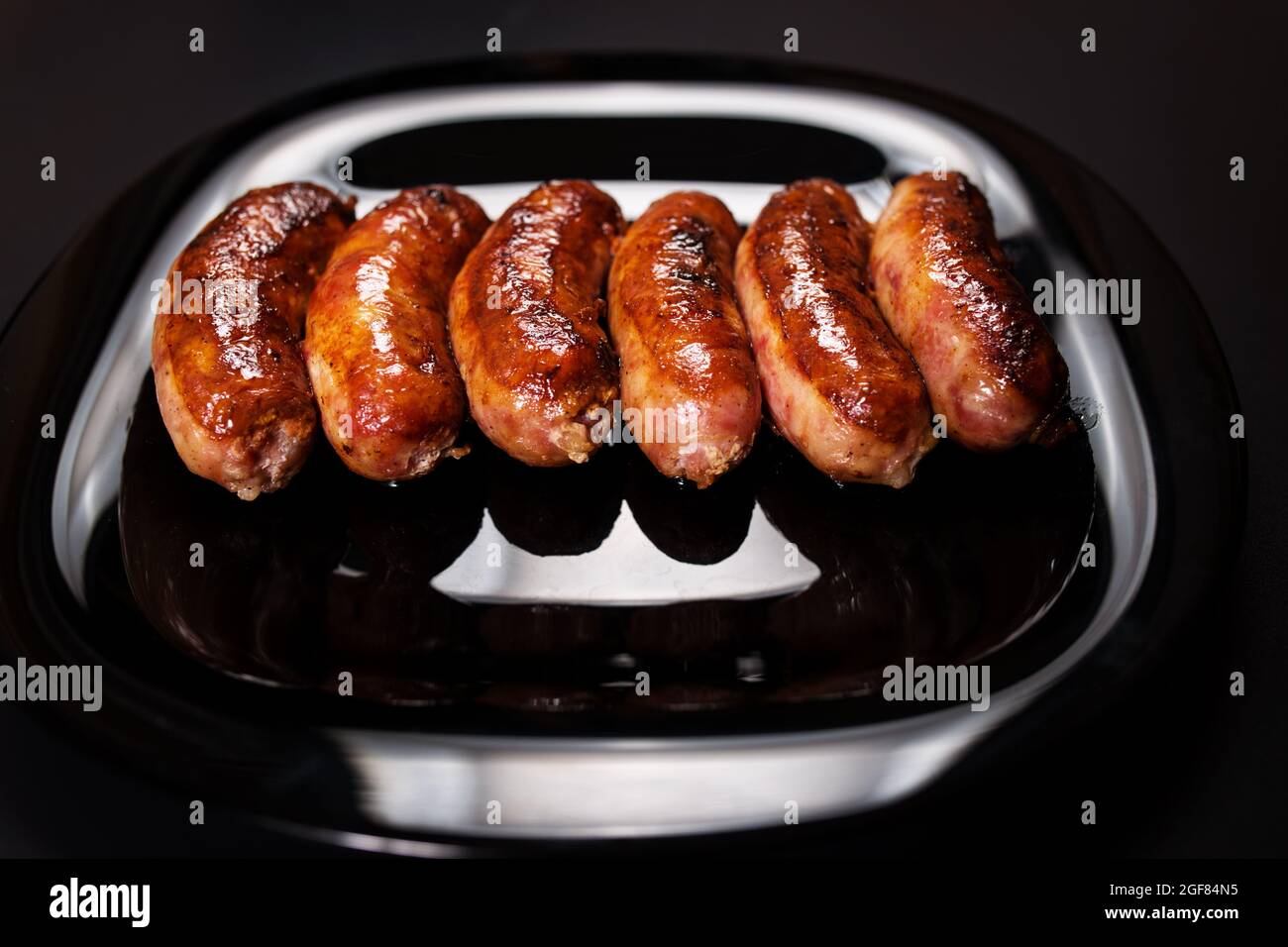 Juicy roasted germany traditional sausages close up, on black