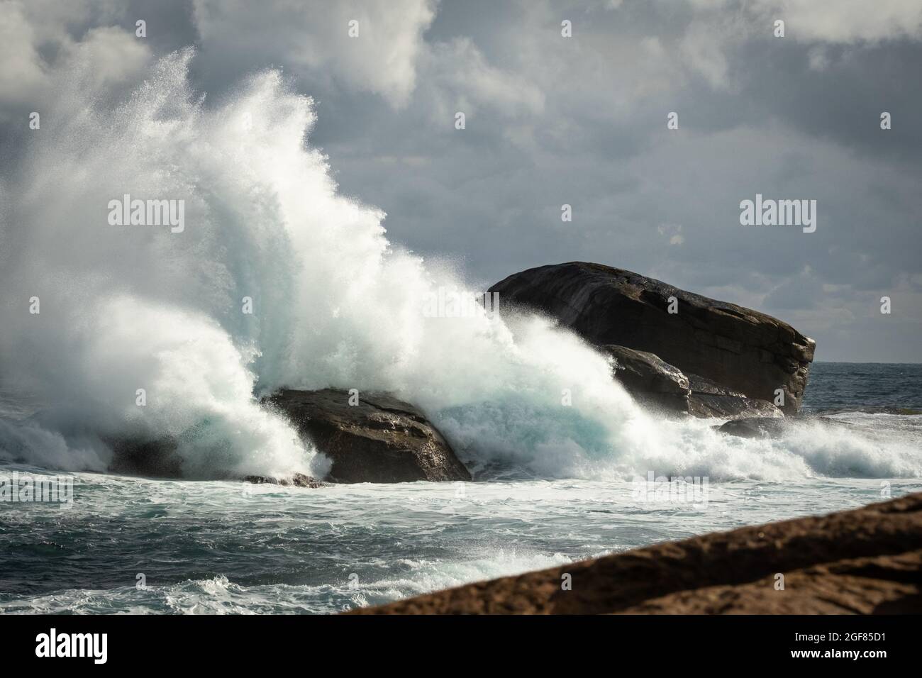 Rough stormy weather big splash of waves on rocks at Redgate Beach, Western Australia Stock Photo