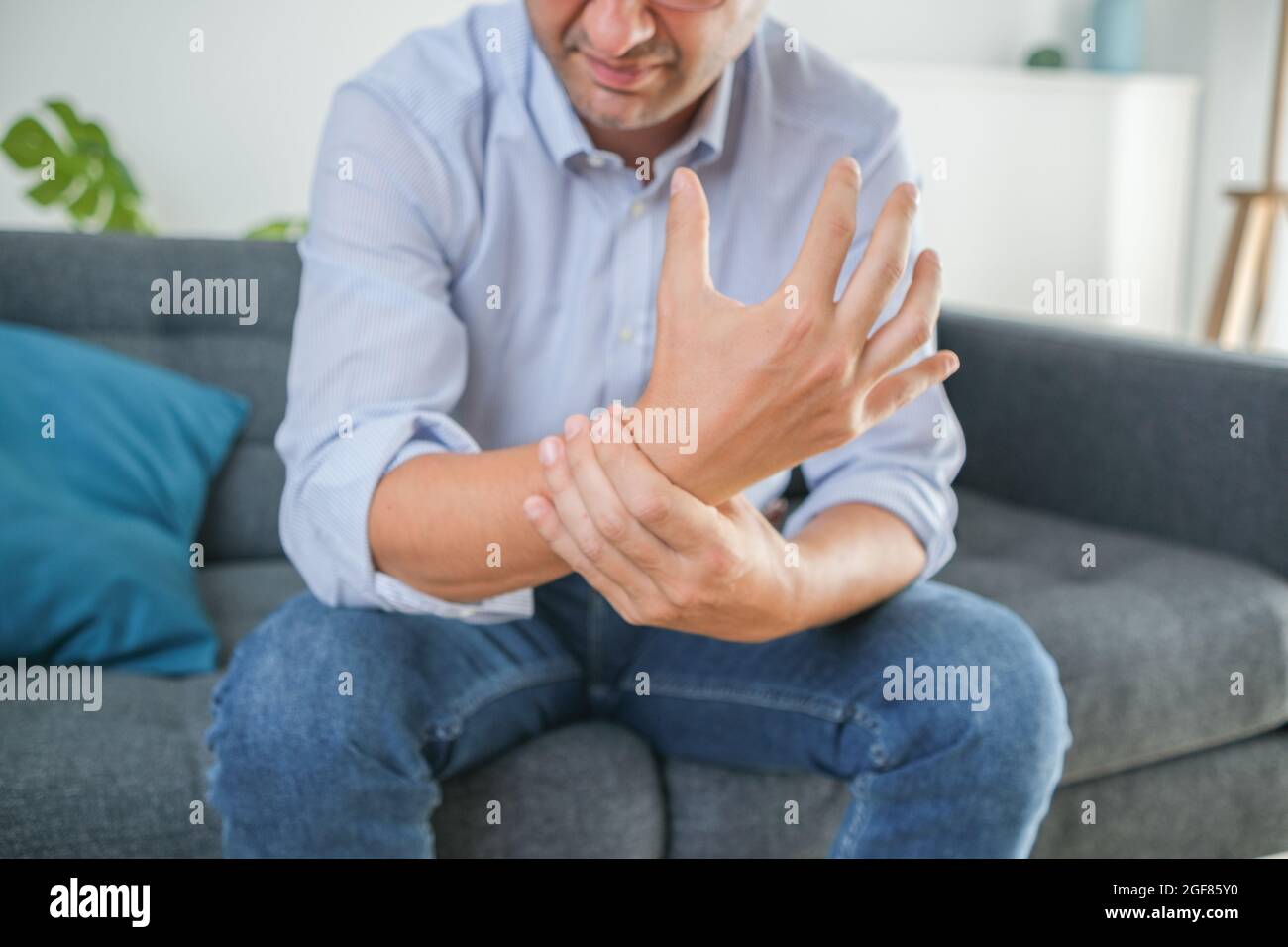 Painful wrist injury symptom after sitting on the sofa Stock Photo