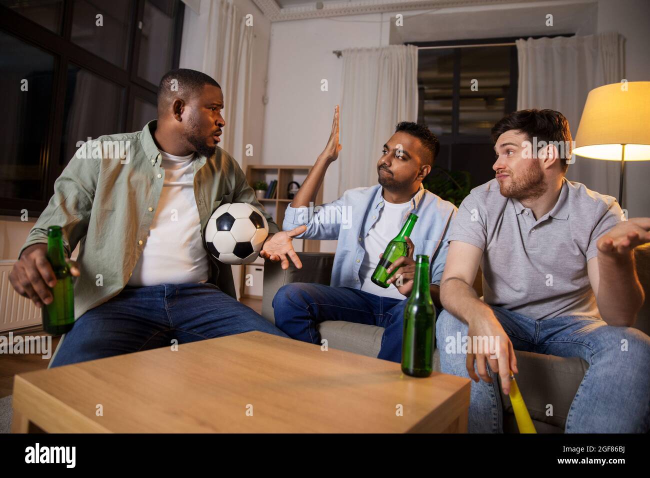 sad friends with ball and vuvuzela watching soccer Stock Photo