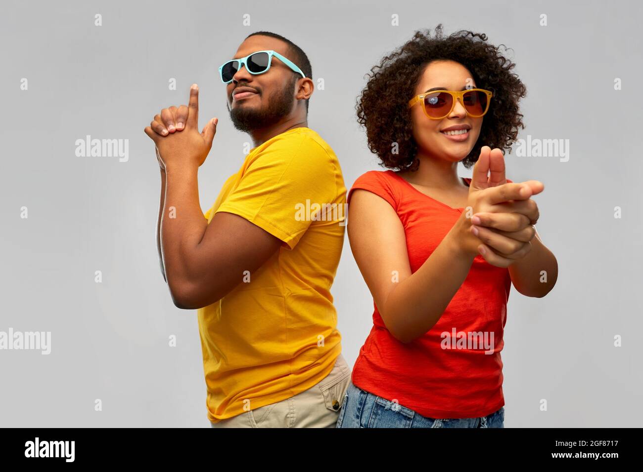african couple in sunglasses makes finger gun Stock Photo