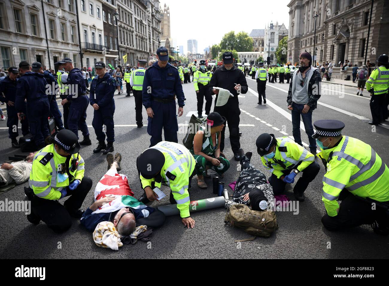Police officers approach protesters chained to each other during an Extinction Rebellion climate activists' protest, outside Her Majesty's Revenue and Customs (HMRC) on Whitehall in London, Britain August 24, 2021. REUTERS/Henry Nicholls Stock Photo