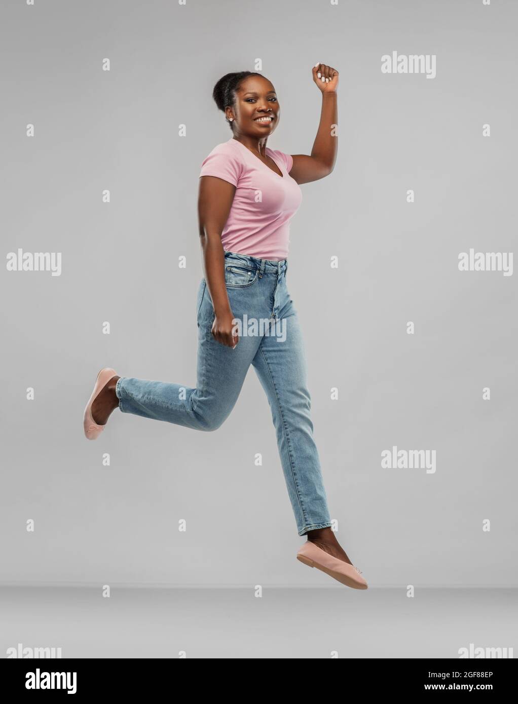 happy african american woman jumping over grey Stock Photo - Alamy