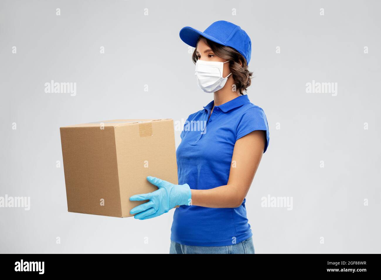 delivery woman in face mask holding parcel box Stock Photo - Alamy
