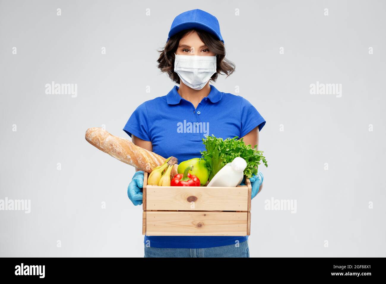 delivery woman in face mask with food in box Stock Photo - Alamy