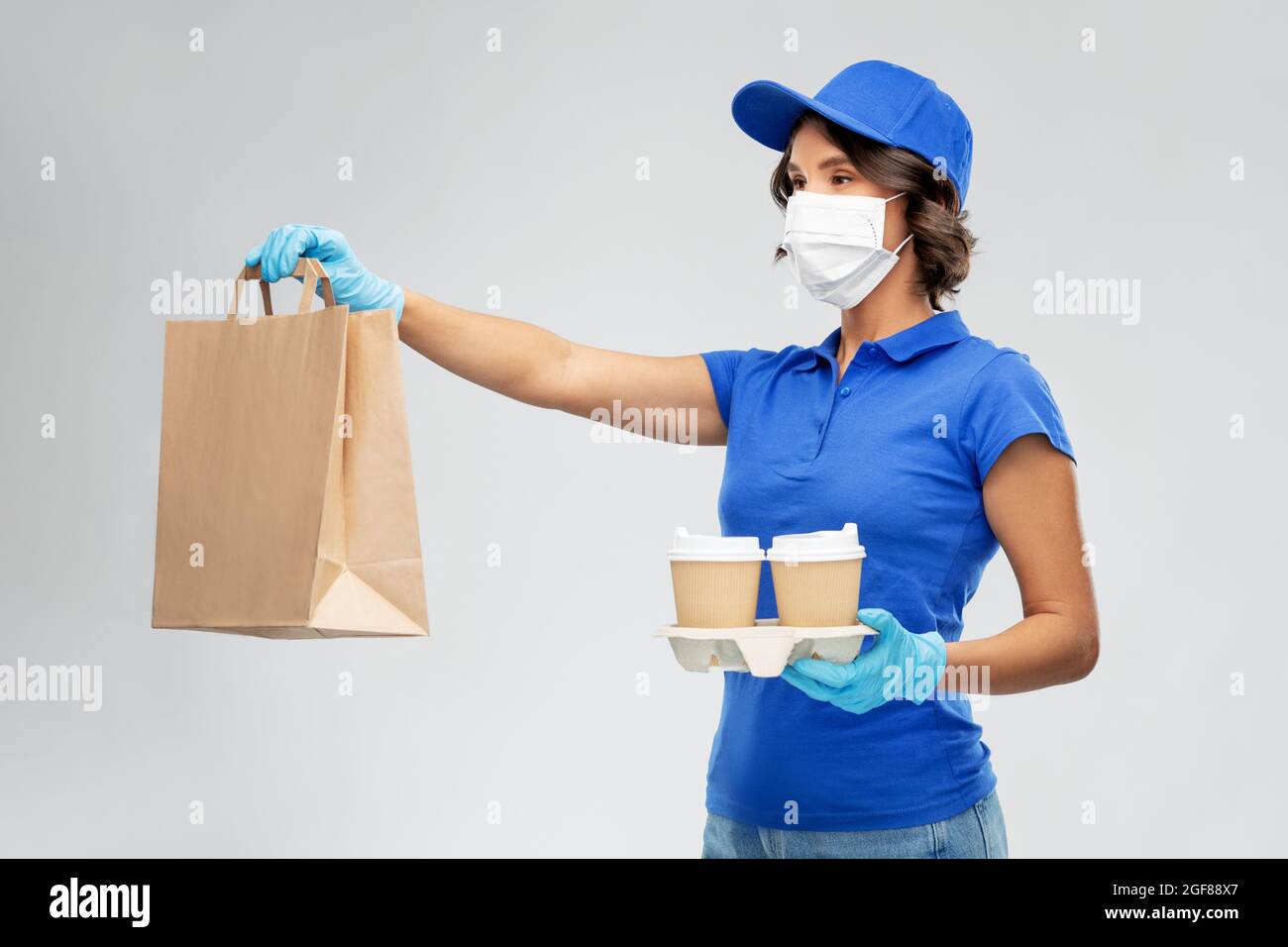 delivery woman in face mask with food and drinks Stock Photo - Alamy