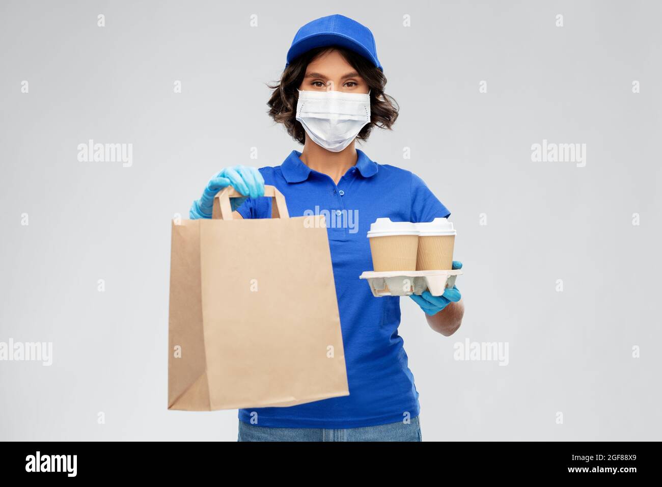 delivery woman in face mask with food and drinks Stock Photo - Alamy