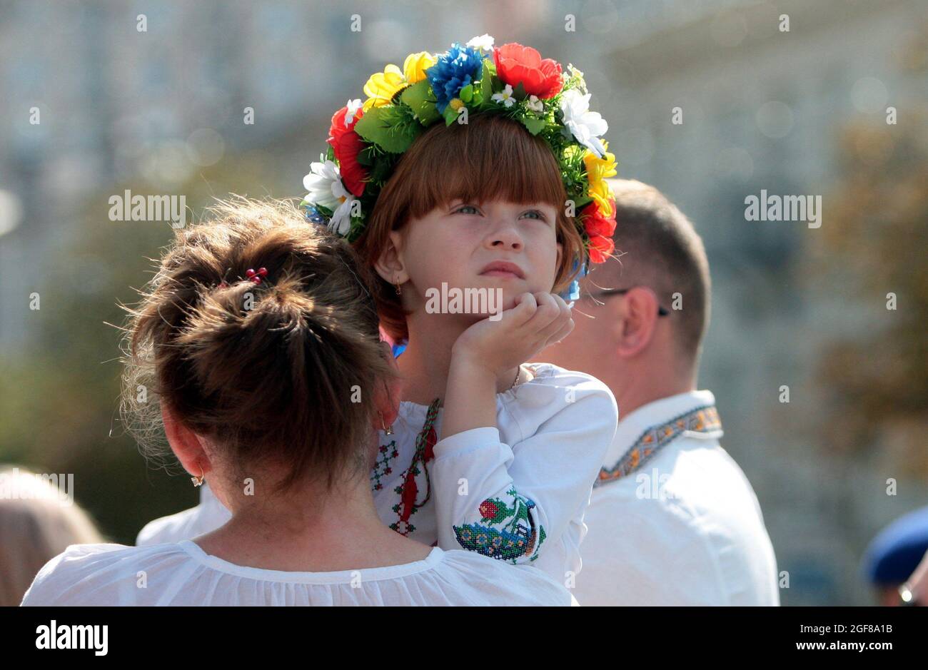 KYIV, UKRAINE - AUGUST 24, 2021 - A woman holds a girl in a floral crown and a vyshyvanka during the 30th Independence Day celebration in central Kyiv Stock Photo