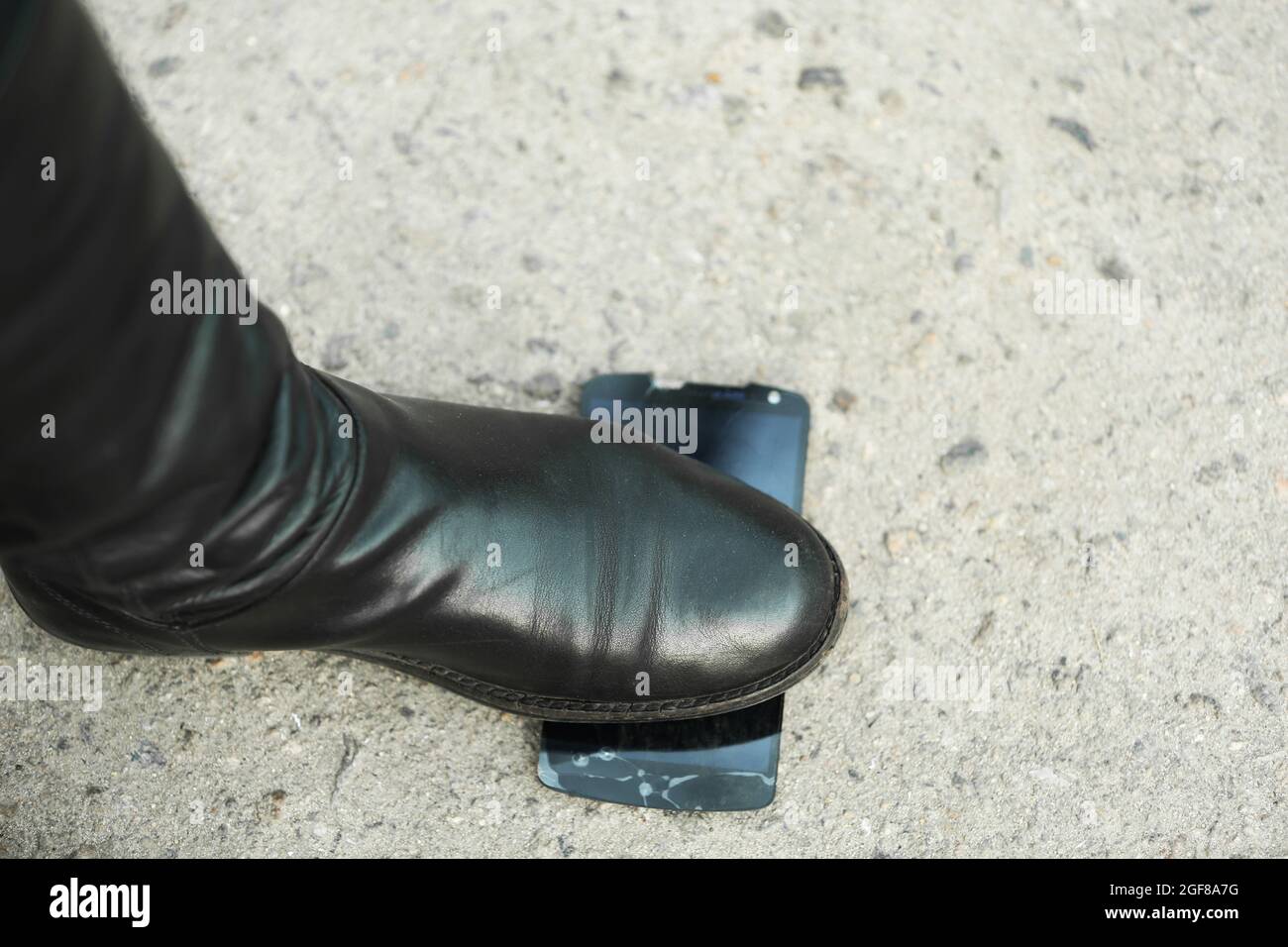 Female boots crushing a mobile phone on the pavement Stock Photo - Alamy