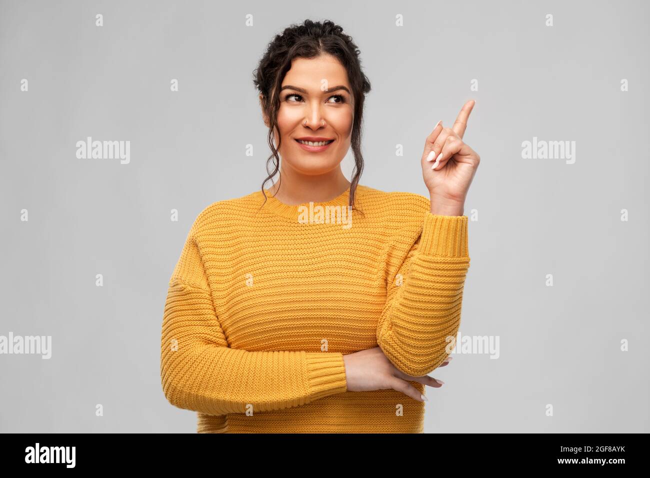 happy smiling young woman pointing finger up Stock Photo