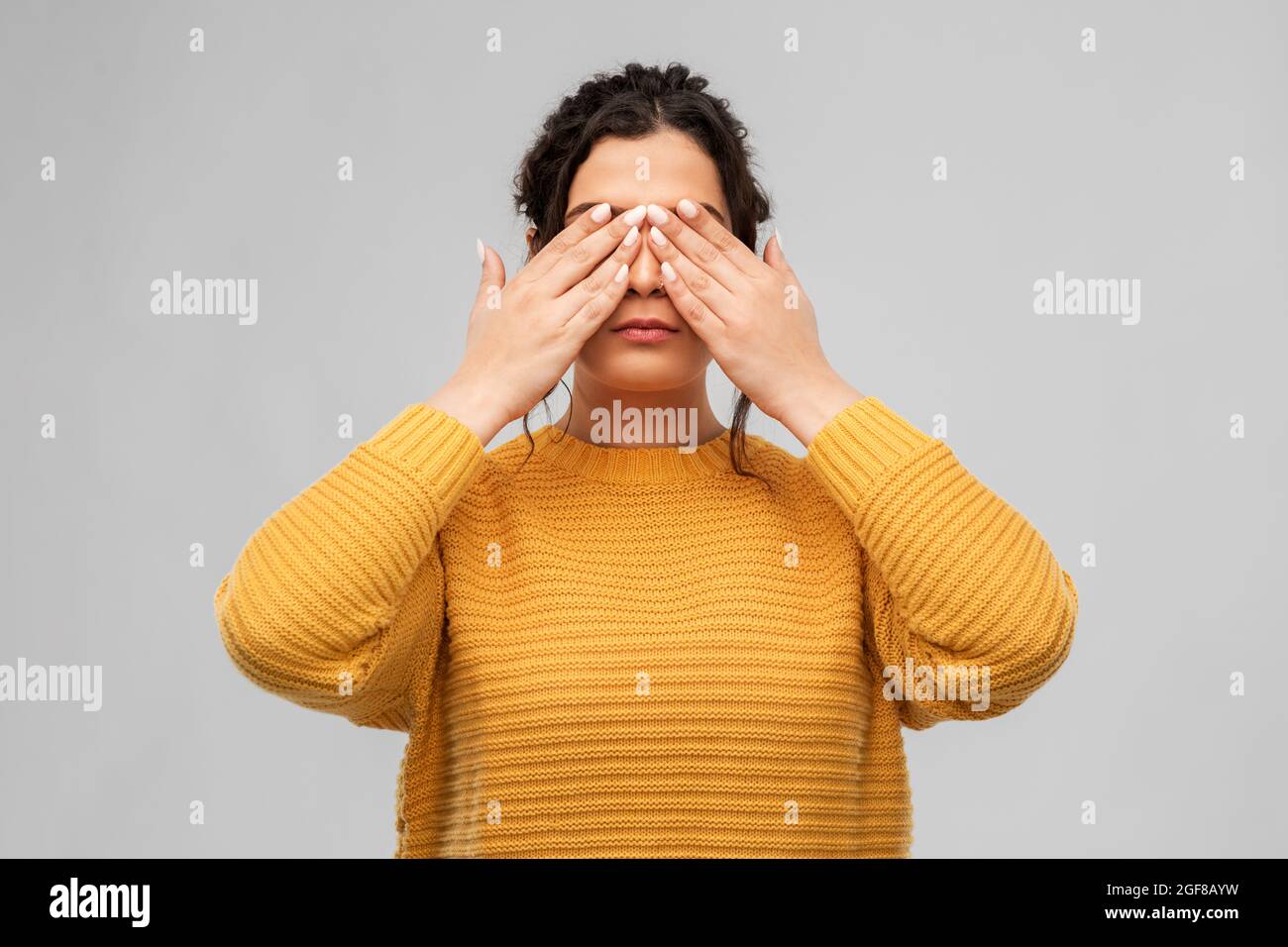 woman with eyes closed by hands Stock Photo
