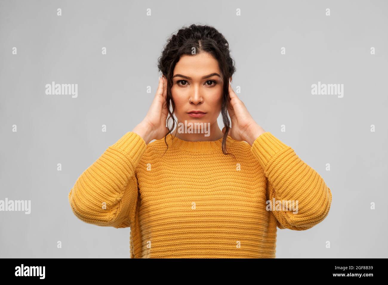 serious woman closing ears with hands Stock Photo