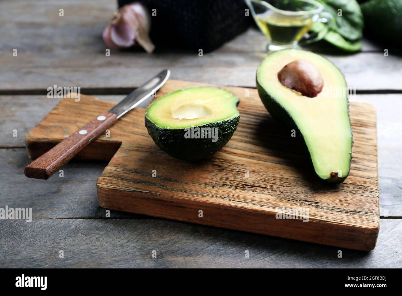 https://c8.alamy.com/comp/2GF8BDJ/sliced-avocado-with-knife-on-wooden-cutting-board-2GF8BDJ.jpg