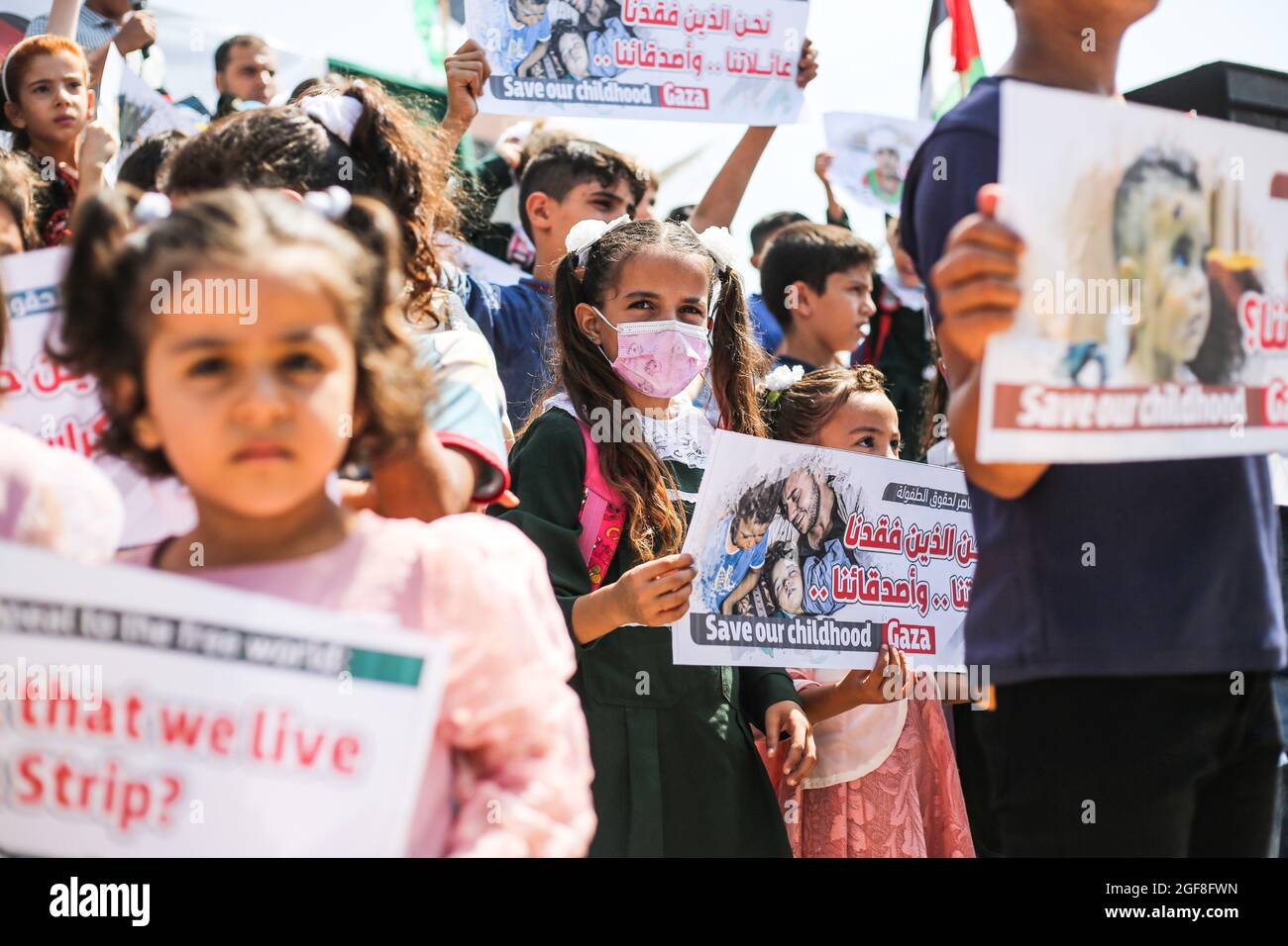 Gaza, Palestine. 24th Aug, 2021. Palestinian children hold banners during an event to send humanitarian messages to the world to end the siege of Gaza by Israel. Credit: SOPA Images Limited/Alamy Live News Stock Photo