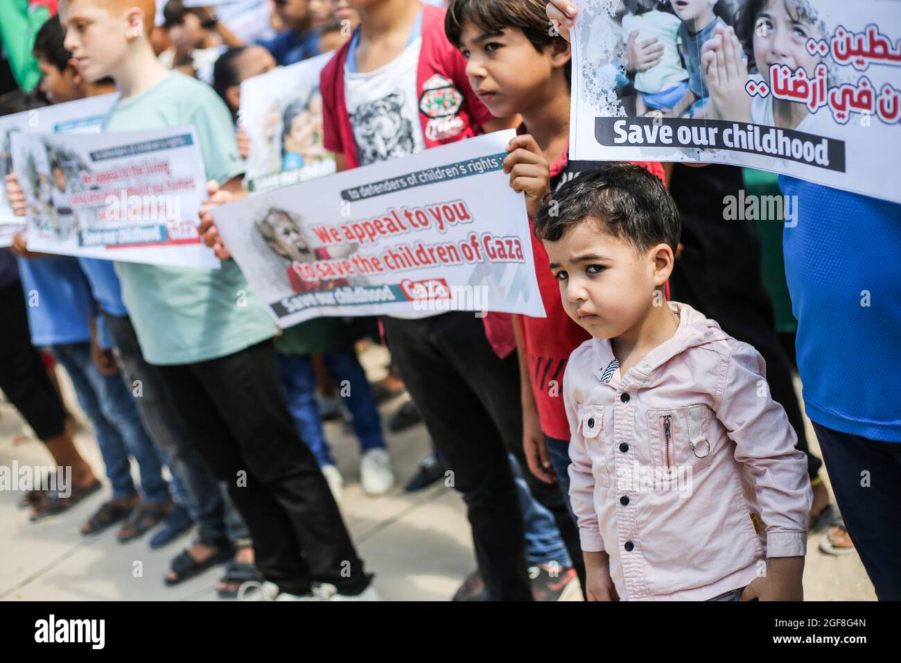 Gaza, Palestine. 24th Aug, 2021. Palestinian children hold banners during an event to send humanitarian messages to the world to end the siege of Gaza by Israel. (Photo by Ahmed Zakot/SOPA Images/Sipa USA) Credit: Sipa USA/Alamy Live News Stock Photo
