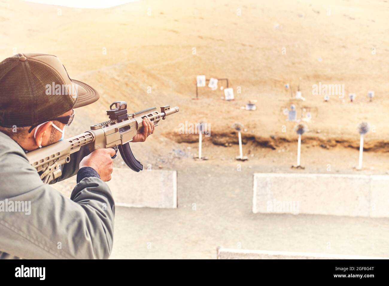 Men practicing shooting with a assault rifle at target. Selective Focus Stock Photo