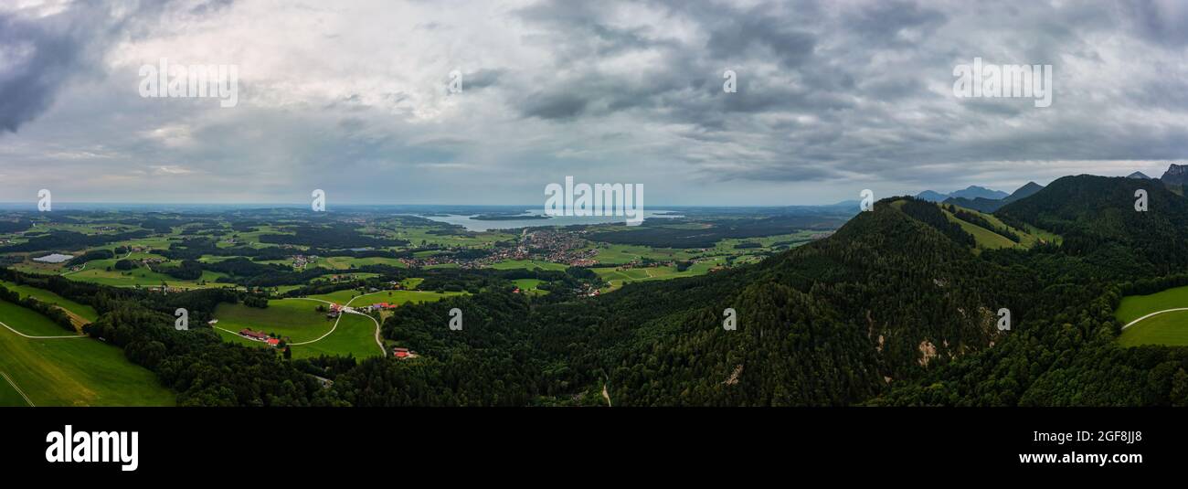 Wide panoramic view over the touristic aera of the Chiemgau alps with the Chiemsee lake next to the horizon. Stock Photo
