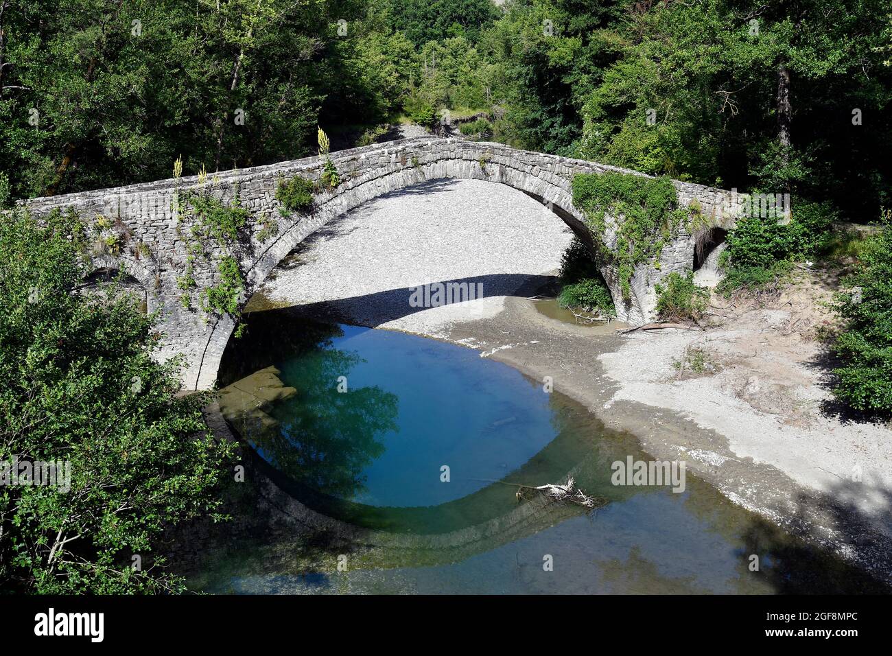 Greece, ancient stone bridge Kamber Aga aka Kamper Aga with reflection in Zagoritikos river Stock Photo