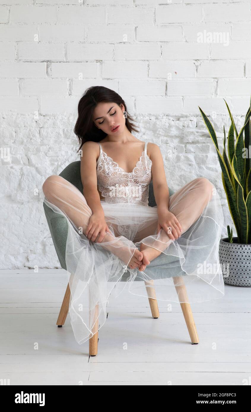 Woman seated in chair wearing lingerie Stock Photo