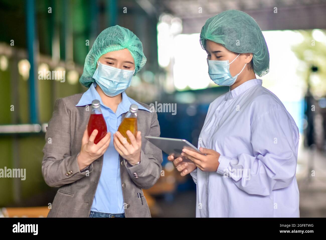 Beverage factory manager talking with operator for expiation work instruction Stock Photo