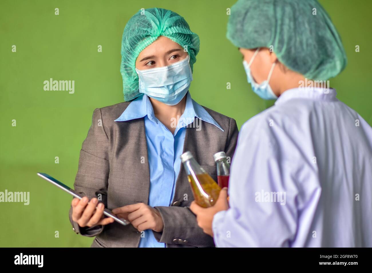 Beverage factory manager talking with operator for expiation work instruction Stock Photo