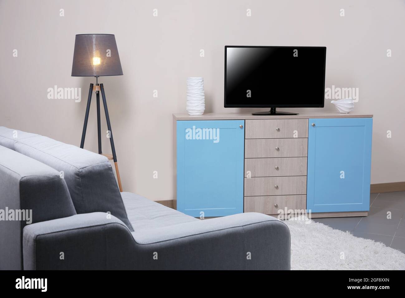 Modern living room with couch and TV Stock Photo - Alamy