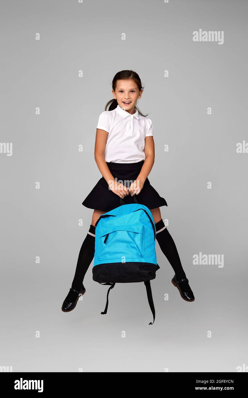 cute happy schoolgirl jumping up with backpack Stock Photo - Alamy