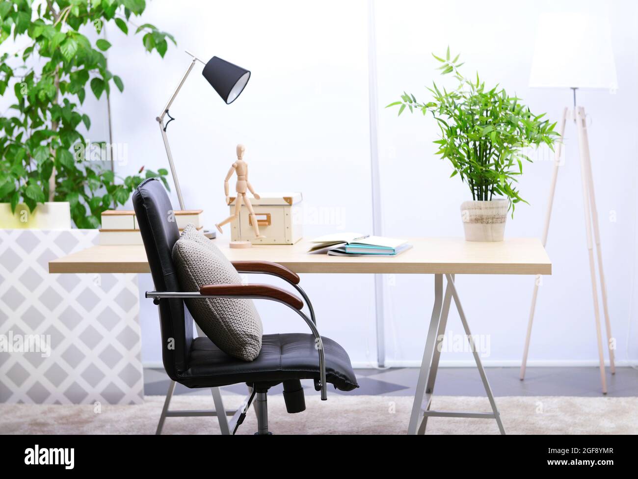 Workplace with table, office chair and lamp in living room Stock Photo