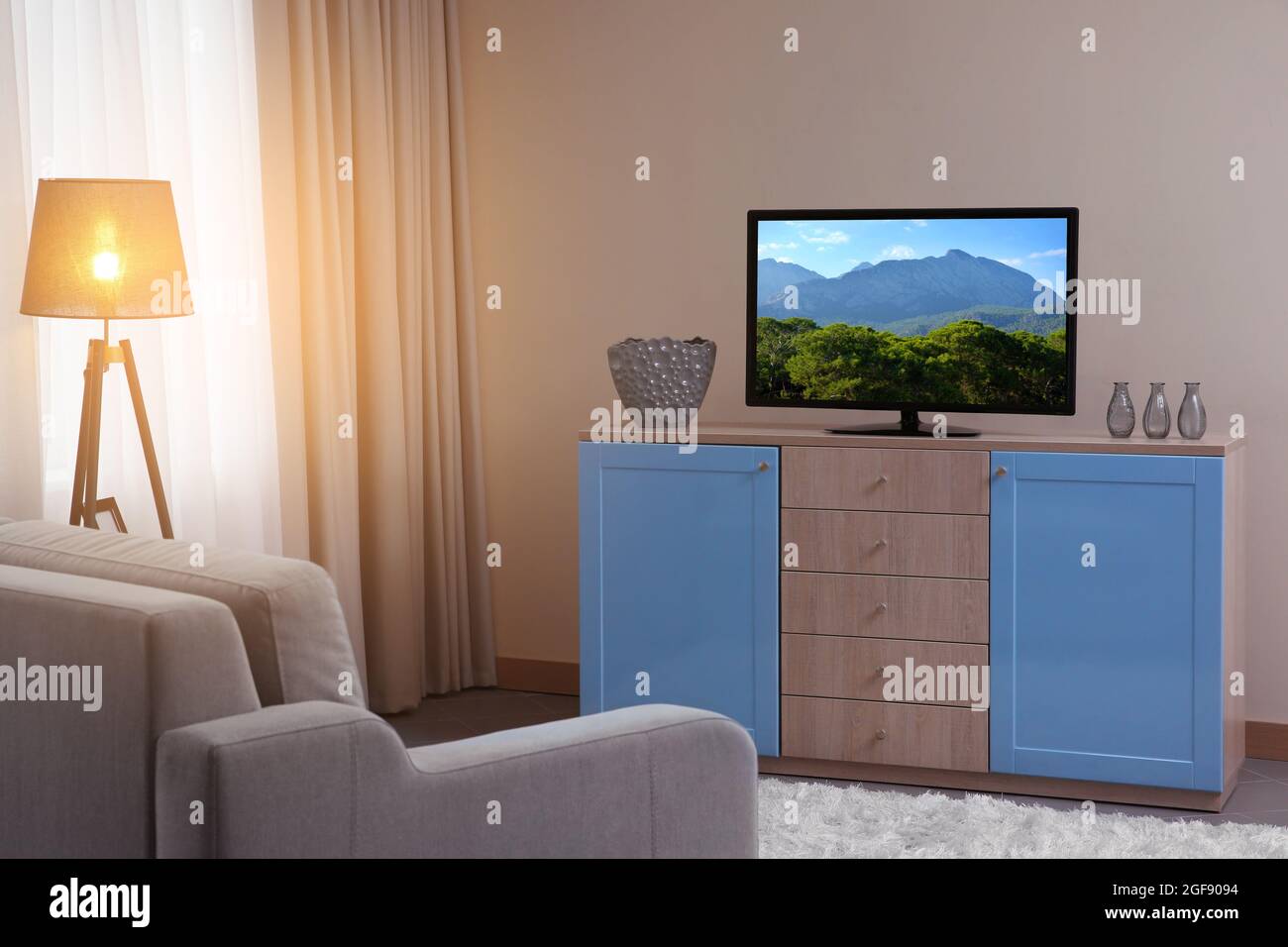 Modern living room with couch and TV Stock Photo - Alamy