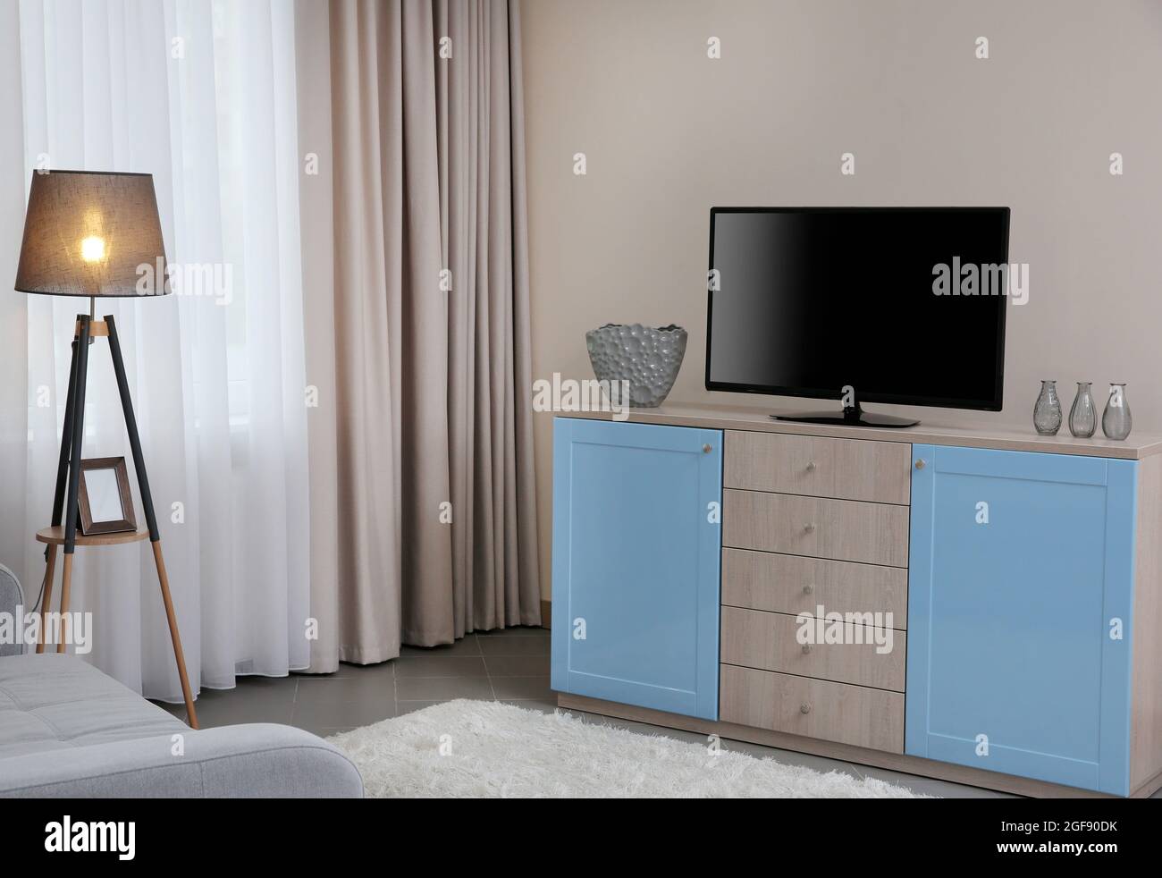 Modern living room with couch and TV Stock Photo - Alamy