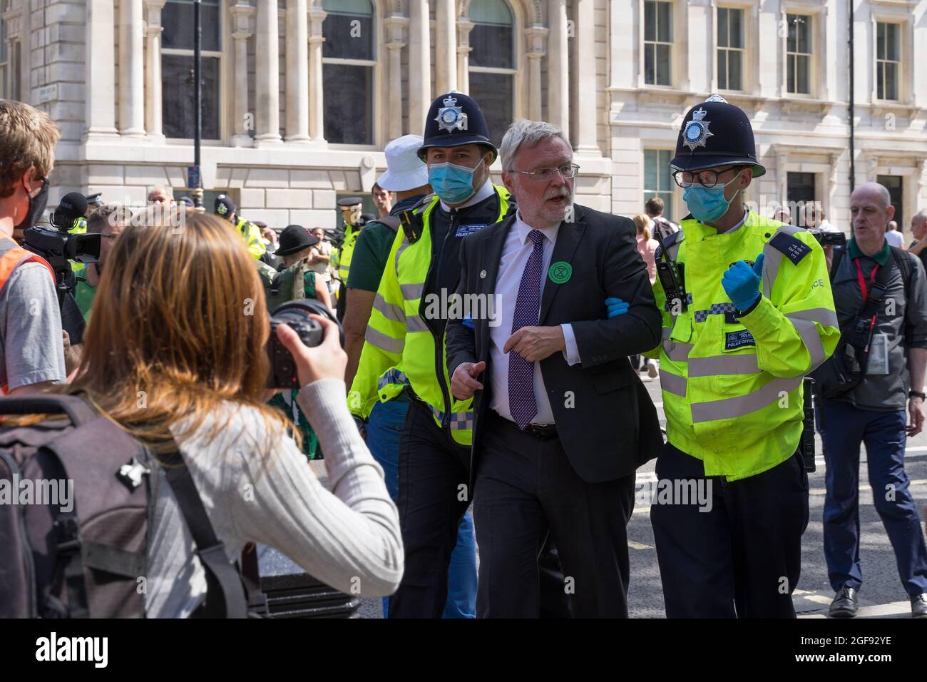 Extinction Rebellion protest down Whitehall in protest against HMRC and Barclays. Man being arrested and walked away by two policemen. London Stock Photo