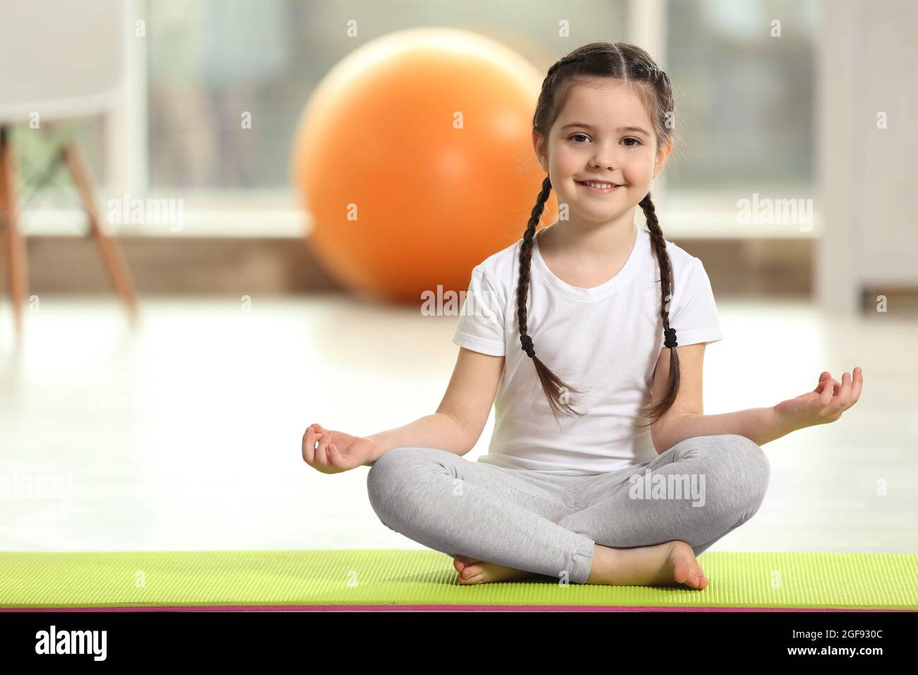 Little cute girl practicing yoga pose on a mat indoor Stock Photo - Alamy