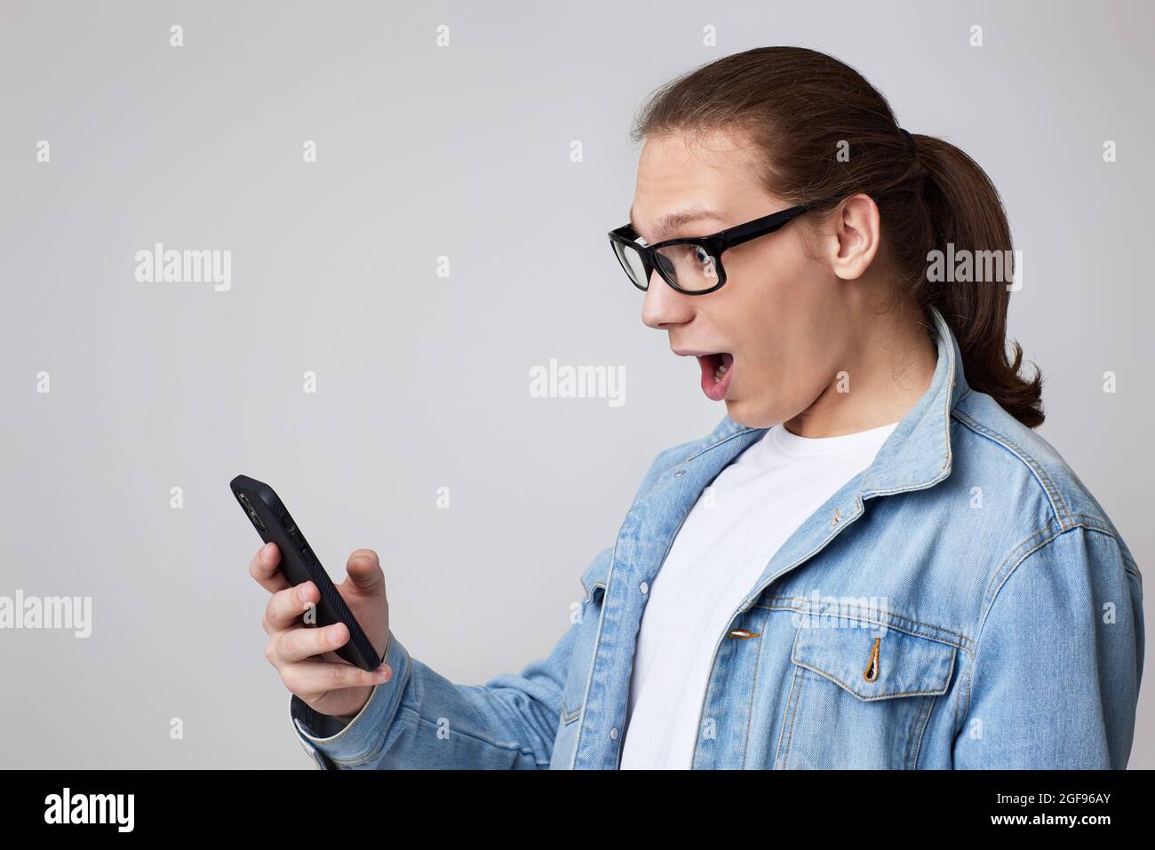 young man in glasses using smart phone Stock Photo