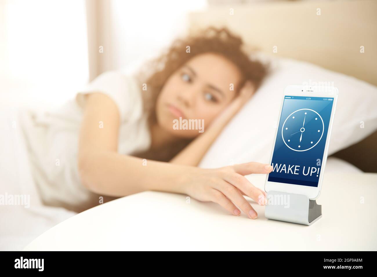 Sleepy girl turning off the alarm clock Stock Photo Alamy