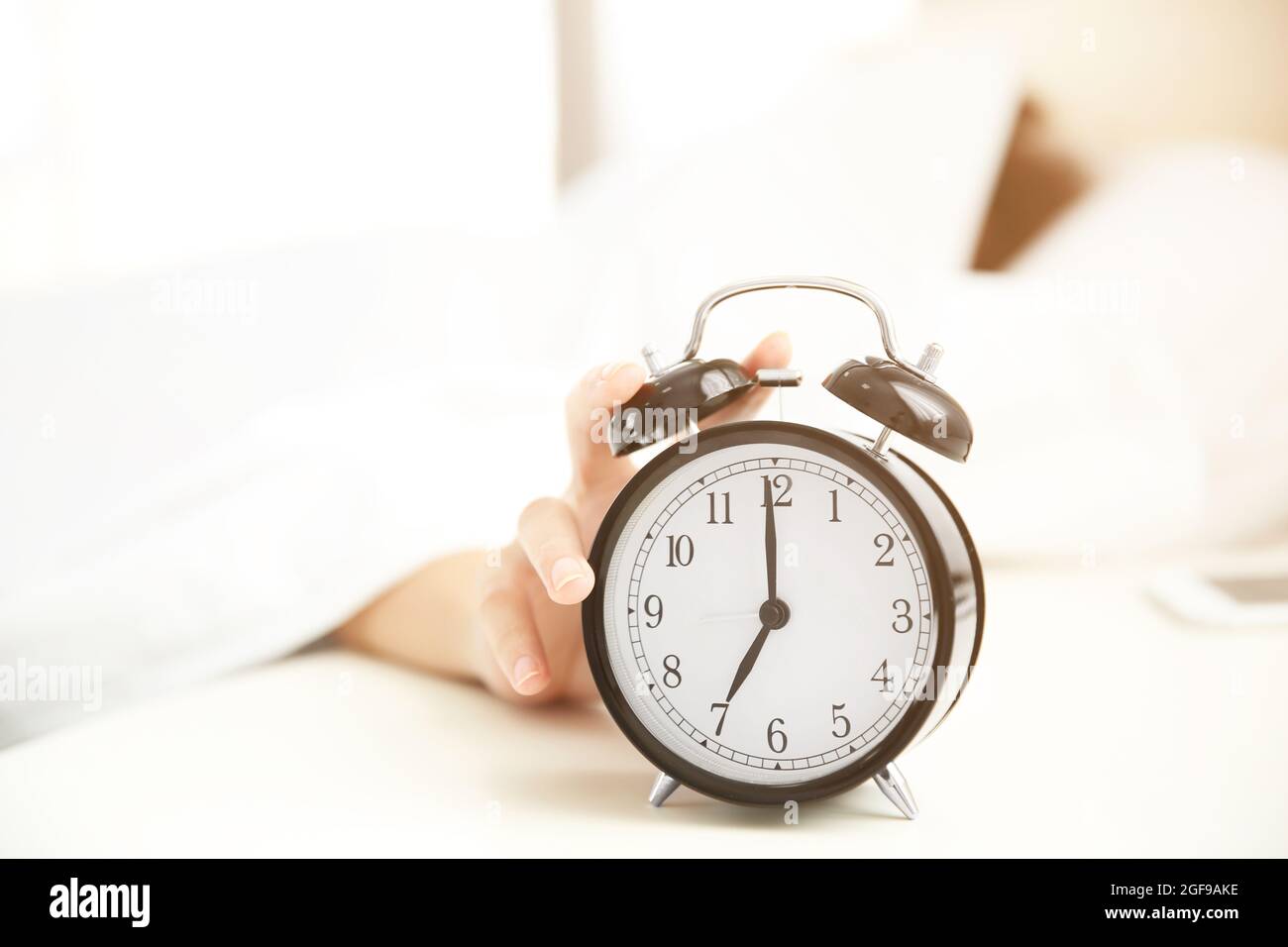 Woman hand stops alarm clock Stock Photo Alamy