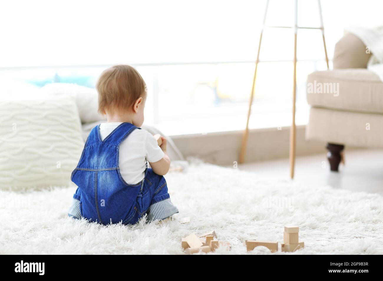Baby playing with meccano on carpet Stock Photo - Alamy