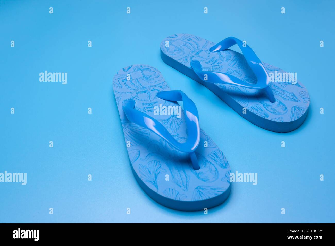 Blue flip flops on a blue background Stock Photo - Alamy