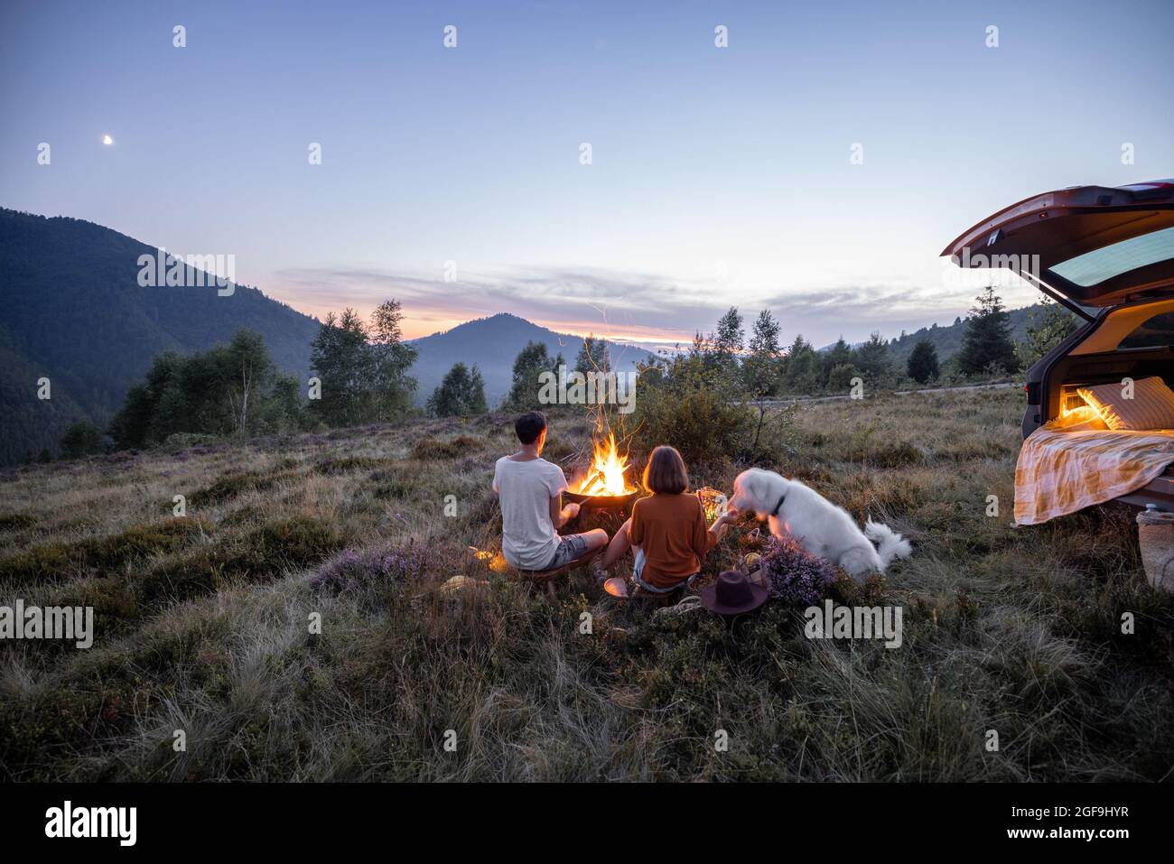 Couple by the fire at picnic in the mountains Stock Photo